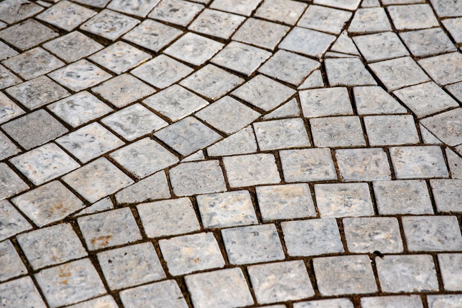 Close-up of weathered cobblestone pavers laid in a fan pattern